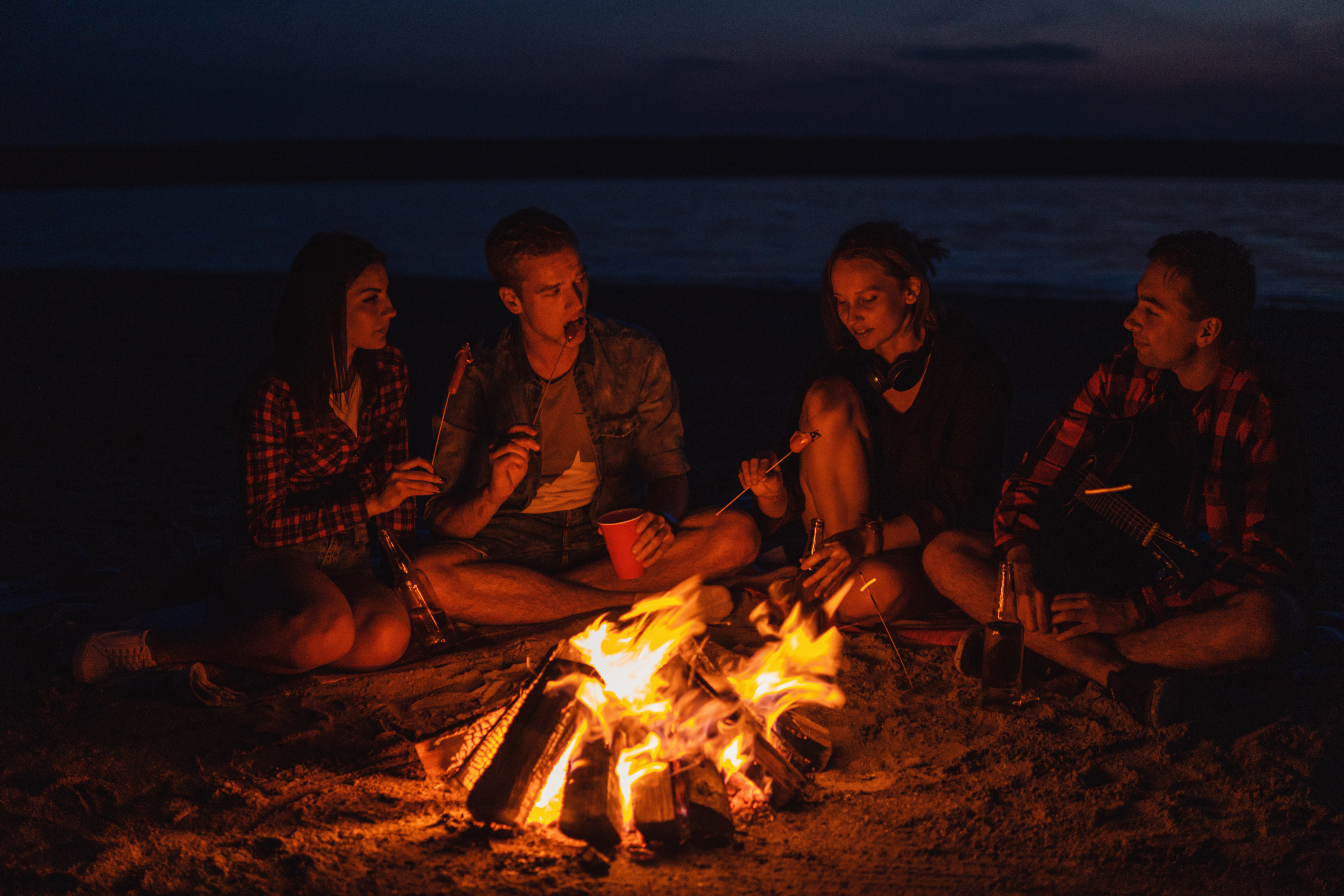 young people around a fire on the beach